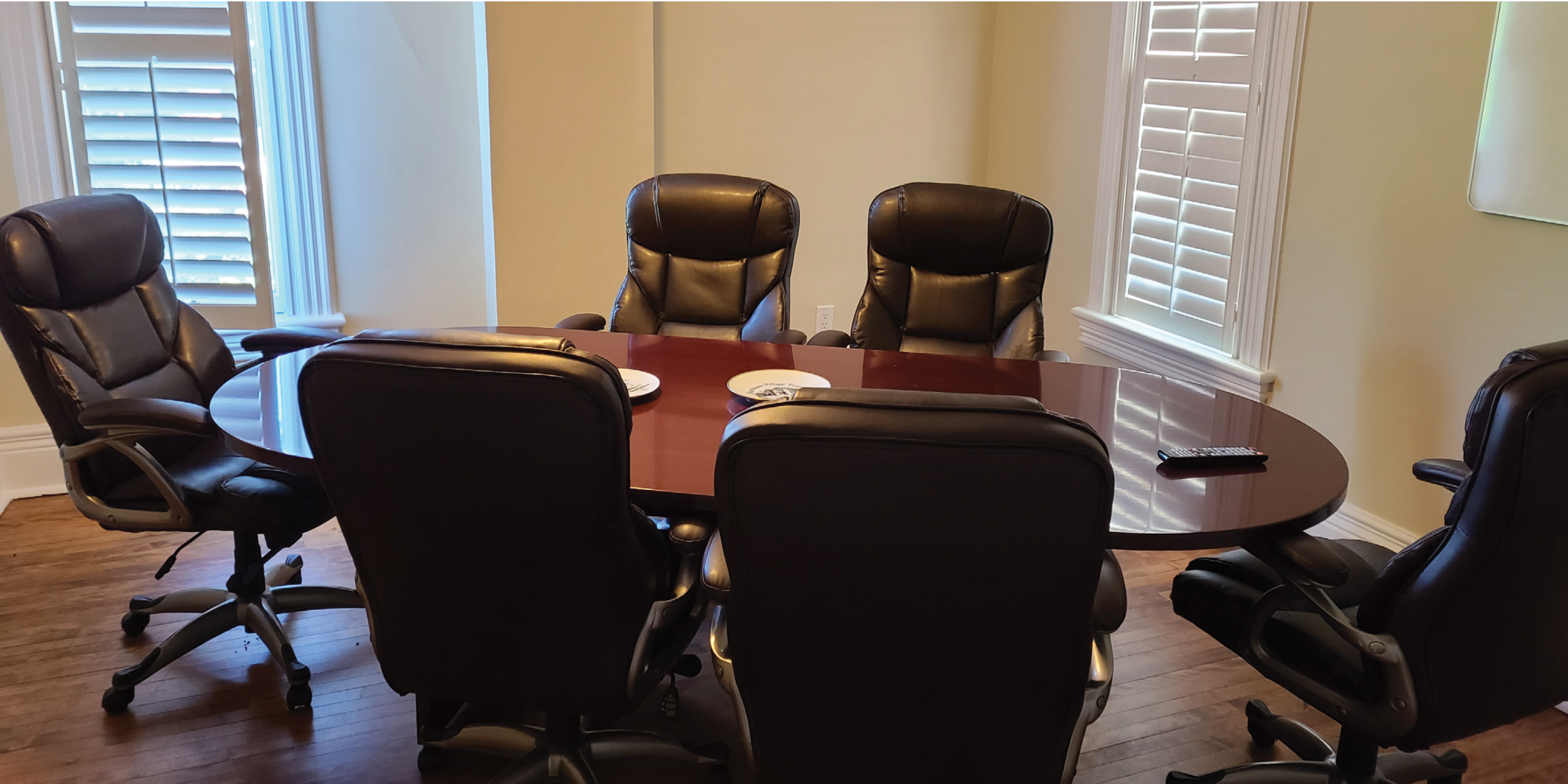 162 Main Street N Meeting area with large wooden table and leather office chairs